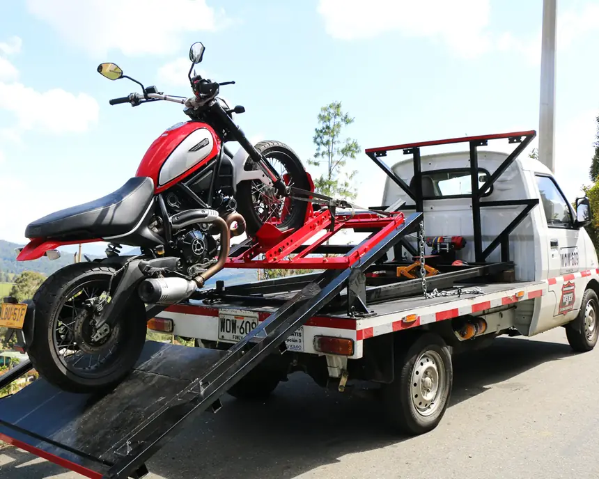 Grúa de Grúas Vélez trasladando una motocicleta en Medellín